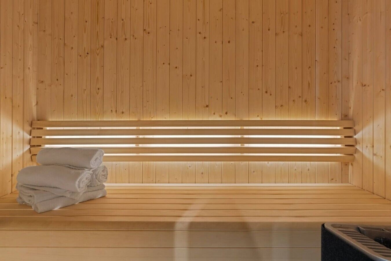 A wooden sauna with benches and towels.