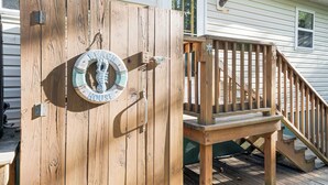 A wooden deck with a wooden staircase leading to a house. - Sundance by Seaside Vacations & Sales (Chincoteague Island)