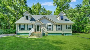 A two-story house with a front porch, a covered entryway, and a small front yard. - Sundance by Seaside Vacations & Sales (Chincoteague Island)