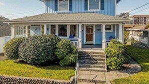 A two-story house with a porch, a chimney, and a well-maintained lawn. - 2 Streets to the Beach! Game Room BBQ & Firepit (Seaside)