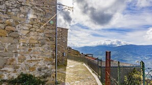 Un bâtiment en pierre, doté d’une clôture en métal et d’un lampadaire.