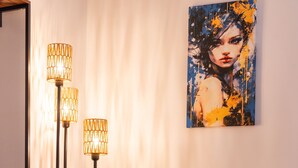 A yellow armchair with a flower-shaped pillow, a floor lamp, and a painting on the wall. - Piazza del Popolo Brunetti apartment (Roma)