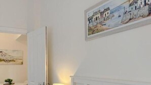 Hotellihuone, jossa on sänky, työpöytä ja tuoli.