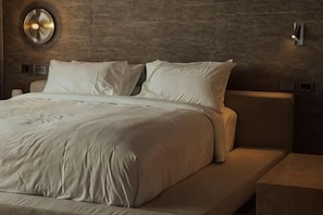 A bed with white linens, a headboard, and a wall-mounted light fixture. - Arthit House Resort Kohlarn (Koh Larn)