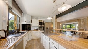 Eine moderne Küche mit weißen Schränken, einer Holz Arbeitsplatte und einem eingebauten Backofen.