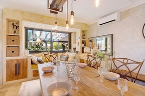 A dining area with a wooden table, chairs, and a large window.