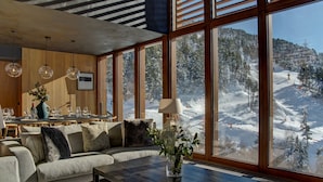 A modern interior with a large window overlooking a snowy mountain.