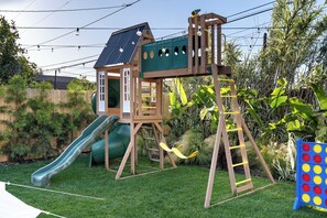Eine Spielkonstruktion für Kinder mit Rutsche, Kletternetz und Schaukeln.
