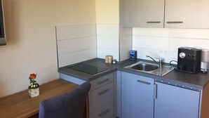 A compact kitchenette with a sink, a coffee maker, and a small vase with a flower on the counter. - Apartment '4' with Shared Terrace and Wi-Fi (Mössingen)