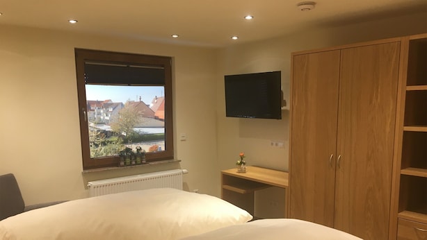 A bedroom with two beds, a window with a view, a TV, and a wooden wardrobe. - Apartment '6' with Shared Terrace and Wi-Fi (Mössingen)