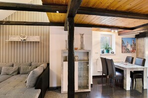 A modern interior with a sofa, dining table, chairs, and decorative items.