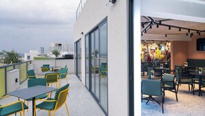 A rooftop terrace with outdoor seating and a view of the cityscape.