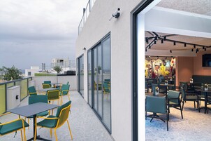Een dakterras met buitenmeubilair en uitzicht op de skyline.