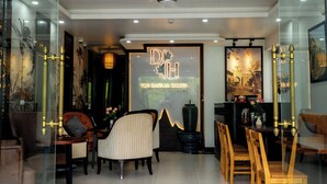 A modern hotel lobby with a reception desk, seating area, and decorative elements.