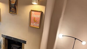Ein Holzespeisesaal Tisch mit einem einzigartigen Design, eine moderne Stehlampe und ein gerahmtes Kunstwerk an der Wand.
