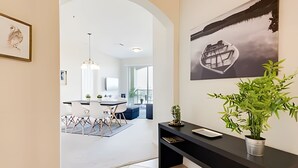 Een modern interieur met een eethoek, een zwarte consoles en een plant, en een lijstwerk met kunst aan de muur.