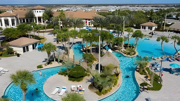 Un complexe hôtelier doté de plusieurs piscines, de palmiers et offrant une vue sur la plage.