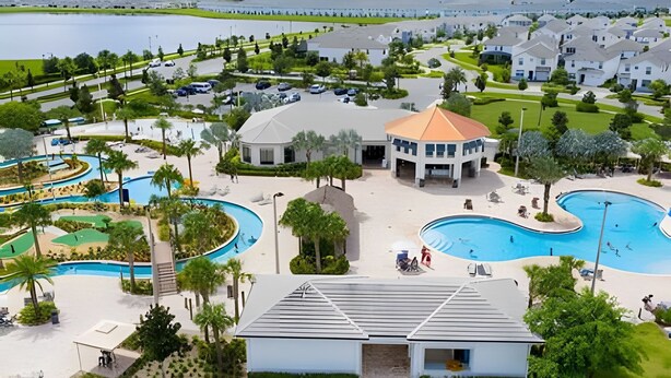 Um resort com uma piscina grande, quadra de tênis e vista para o lago.