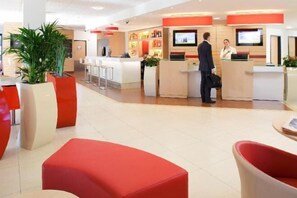 A hotel lobby with a reception desk, seating areas, and a bar. - Ibis Lagos Ikeja (Ikeja)