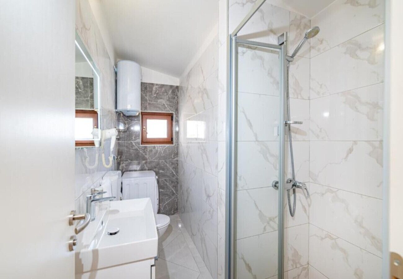 Ein Badezimmer mit Dusche, Toilette und Waschbecken.