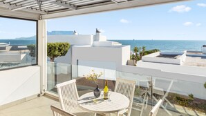 A balcony with a glass table, white chairs, and a bottle of wine. - 19 Ascension (Cape Town)