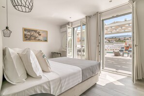 Une chambre à coucher avec un lit, un tableau et une vue sur le balcon extérieur.