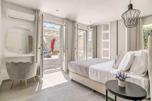 Ein modernes Schlafzimmer mit einem großen Bett, einem Nachttisch mit einer Vase und Blick ins Freie.