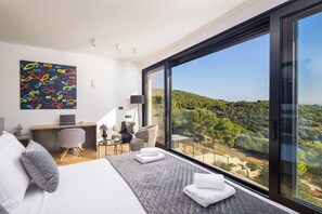 A modern hotel room with a large bed, a desk, and a view of a green landscape. - Incredible divine view 5-bedroom villa in Vis Town (Vis)