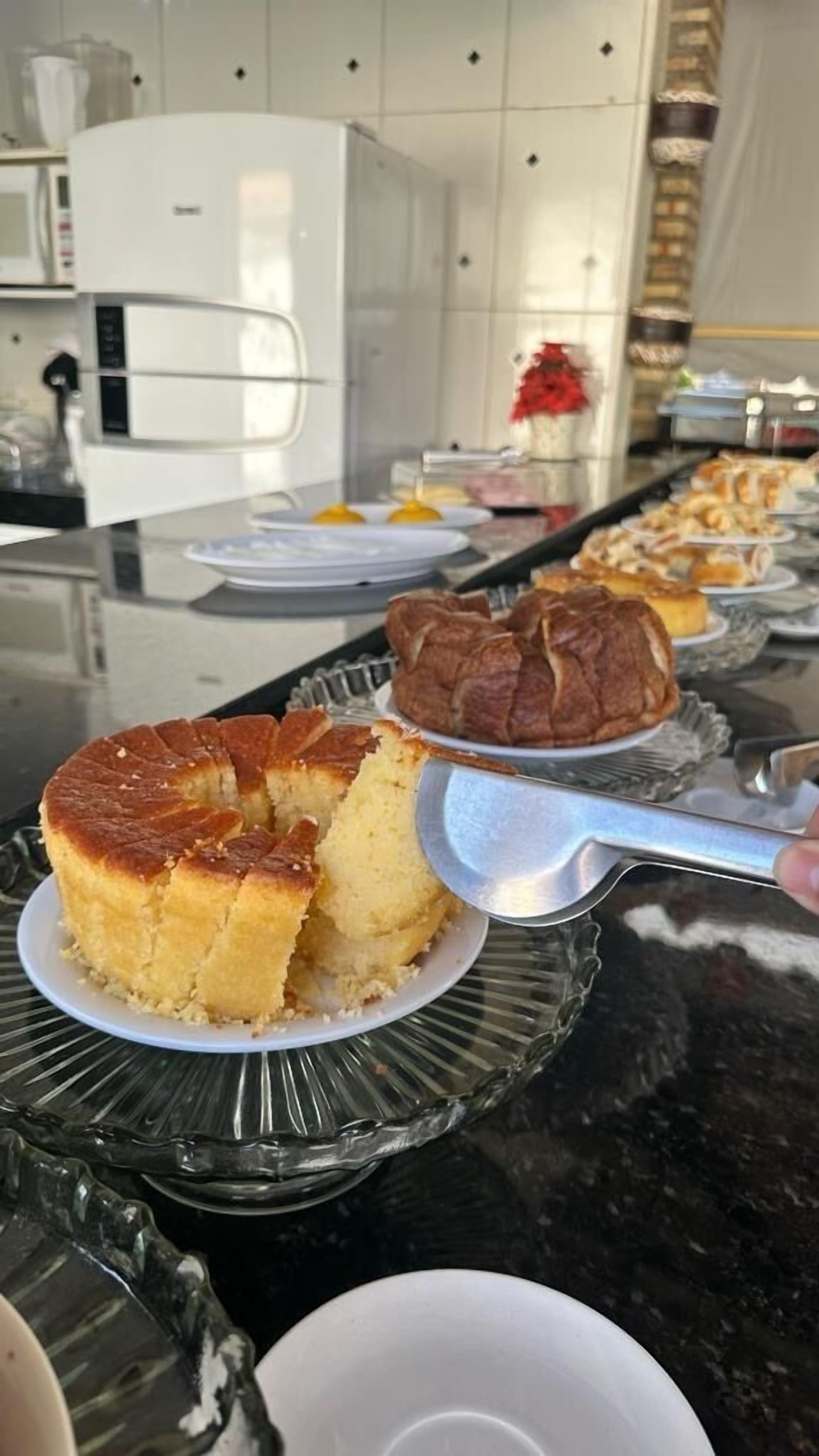 Buffet com diversos alimentos, incluindo um bolo em um prato.