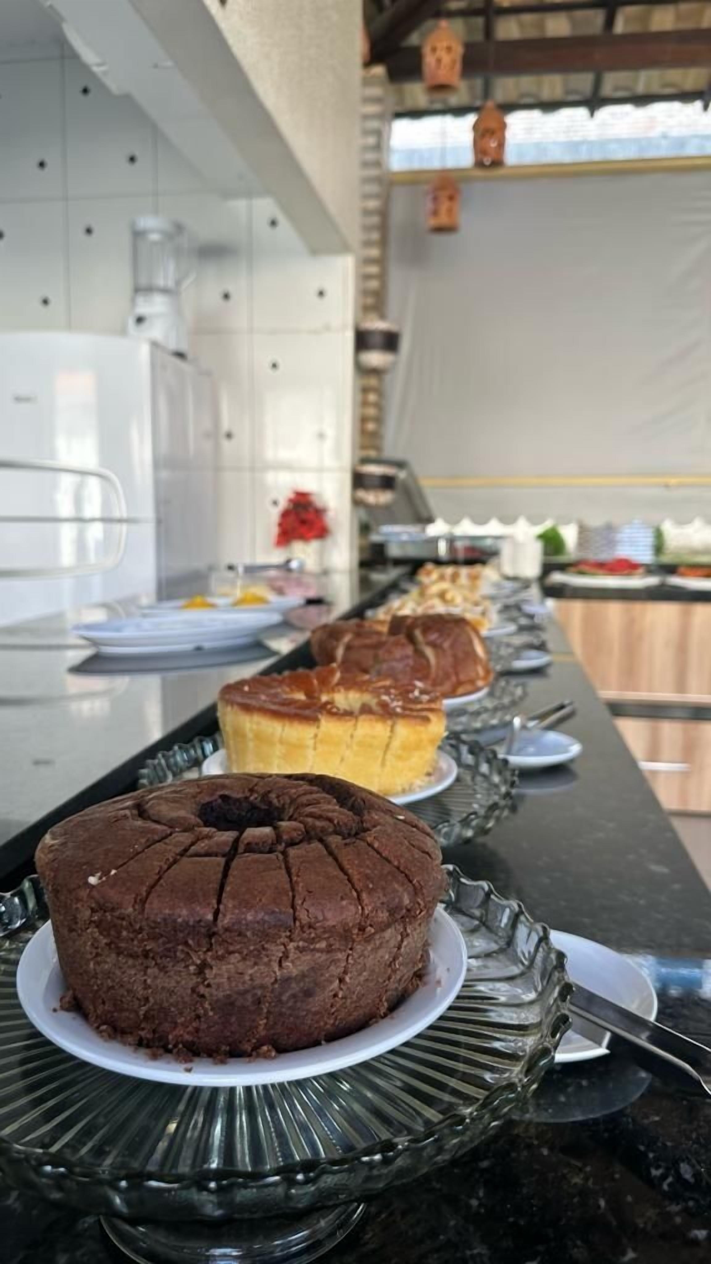 A buffet table with various baked goods, including cakes and pastries, displayed on plates.