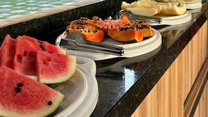 Een ontbijtbuffet met diverse soorten fruit en gerechten.