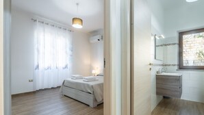 Ein Schlafzimmer mit Bett, Nachttisch und einem Fenster mit Vorhängen.