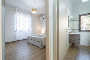 Une chambre à coucher avec un lit, une table de chevet et une fenêtre avec des rideaux.