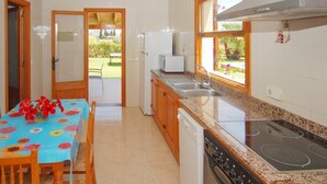 Una cuina amb taula de dinar, microones, rentapelats i fogó.