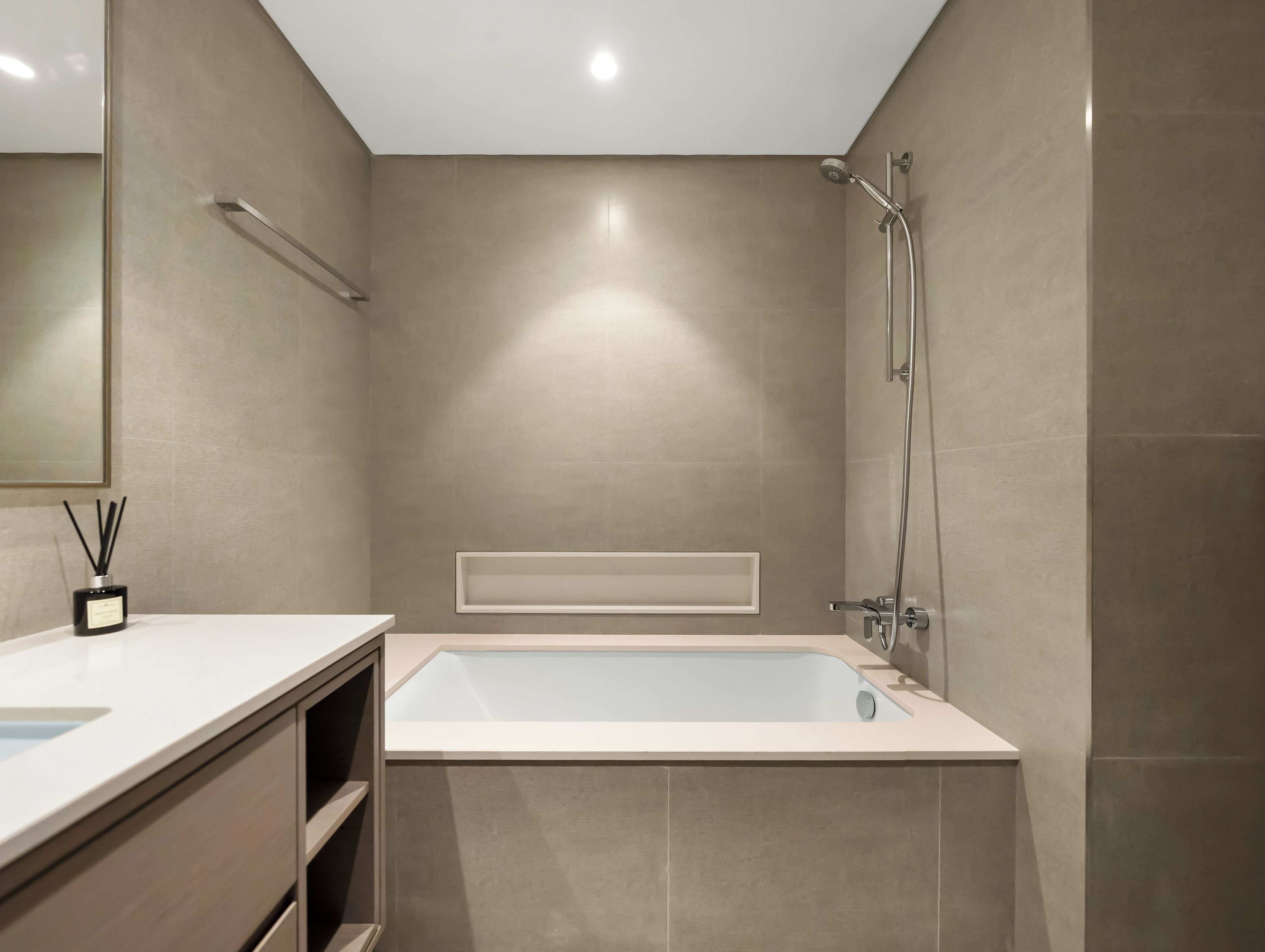 A modern bathroom with a large bathtub, a shower, and a vanity with a mirror.