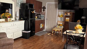 A compact kitchen with a refrigerator, microwave, and wooden cabinets.