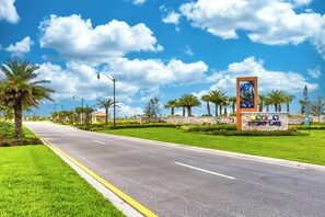Eine breite Straße mit einem Storey Las Vegas Schild, Palmen und wolkenlosem, blauem Himmel.