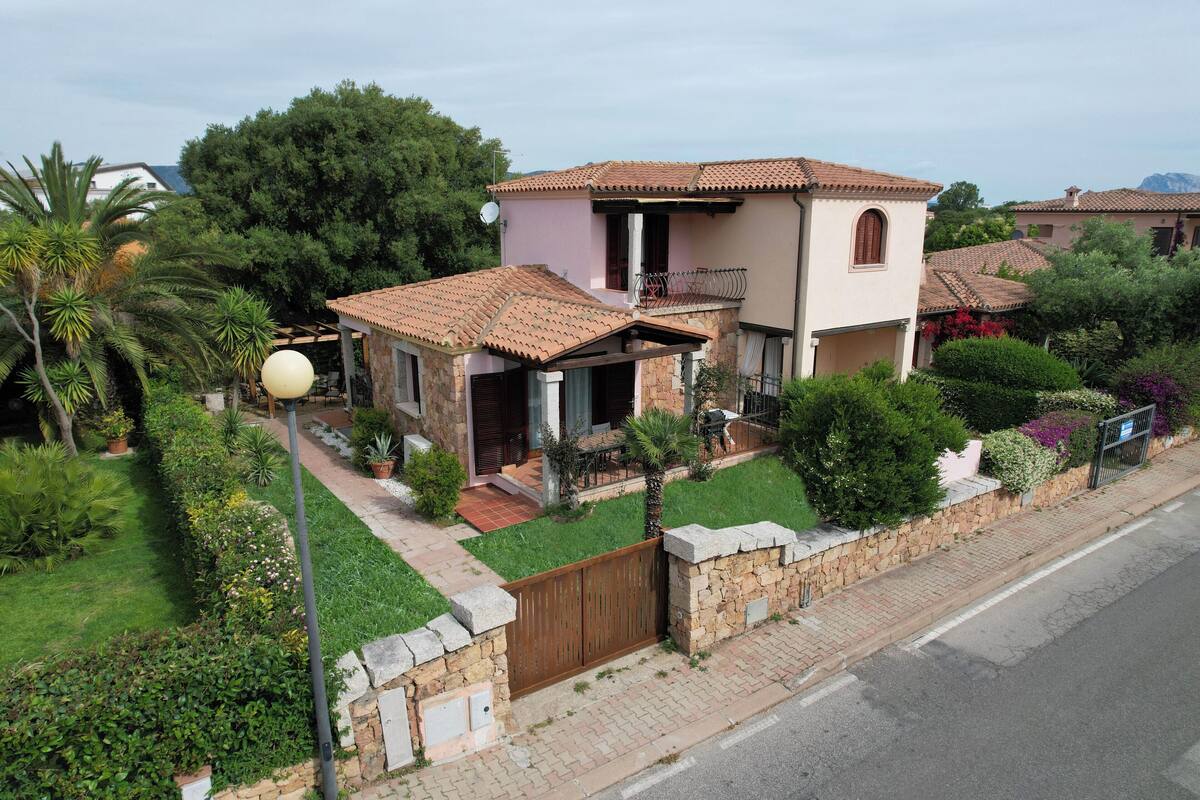 Une maison à deux étages, avec un toit en tuiles, un balcon et un mur en pierre.