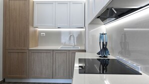 Une cuisine moderne avec des meubles en bois, un évier en acier inoxydable et un plan de travail noir.