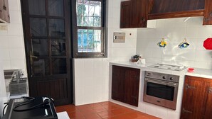 Une cuisine équipée d’une cuisinière, d’un four et de placards.