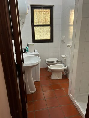 Ein kleines Badezimmer mit Toilette, Bidet und Waschbecken.