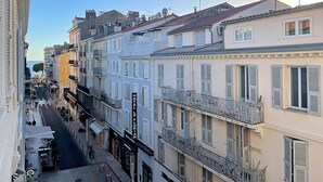 A row of European-style buildings with balconies, a street in the foreground, and a clear sky. - Viva Riviera Design and Sunny Commandant André (Cannes)