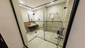 Une salle de bain moderne avec une douche à parois de verre, un lavabo et un porte-serviettes.