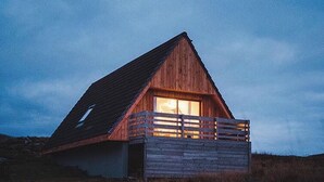 Eine Holzhütte mit geneigtem Dach und einem Balkon.