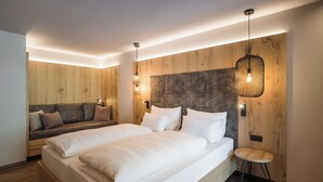 Un dormitorio moderno con una cama grande, un sofá y un taburete pequeño.