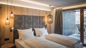 Un dormitorio moderno con una cama grande, dos mesitas de noche y un cabecero de madera.