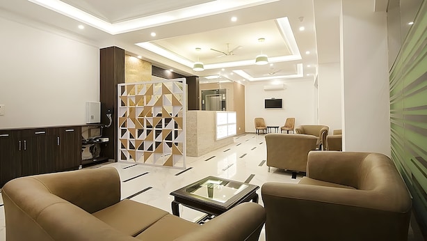 A modern lobby with seating, a reception desk, and a TV. - 99 Hotel Apple Park (New Delhi)