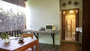 A small kitchen with a microwave, a scale, and a window with a view of trees. - Baannoi Retreat and Stay Chiang Mai (Chiang Mai)