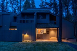 Ein zweistöckiges Haus mit sichtbarer Garagentür und einer beleuchteten Außenleuchte.