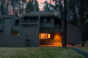 Une maison moderne à deux étages, dotée d’un porche avant couvert et d’une petite terrasse.
